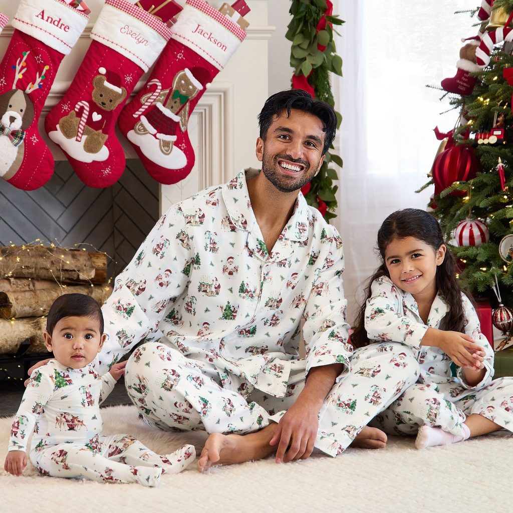 Dad and children wearing matching Holly Jolly Santa Christmas pajamas