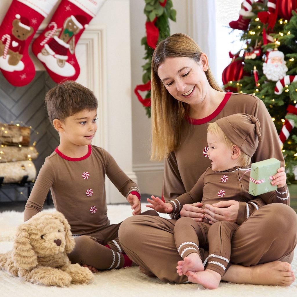Mom and children wearing matching gingerbread holiday pajamas
