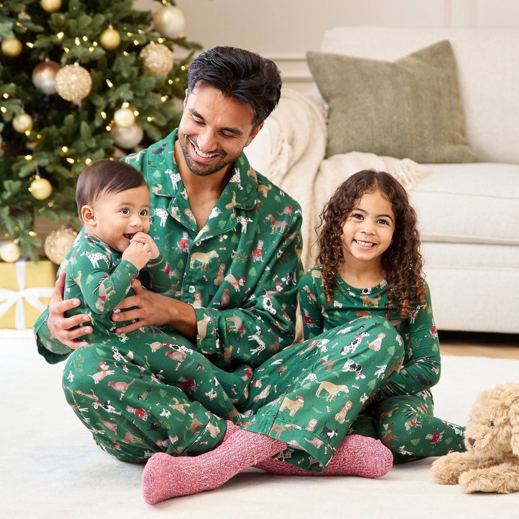 Dad and children wearing matching green holiday dog Christmas pajamas