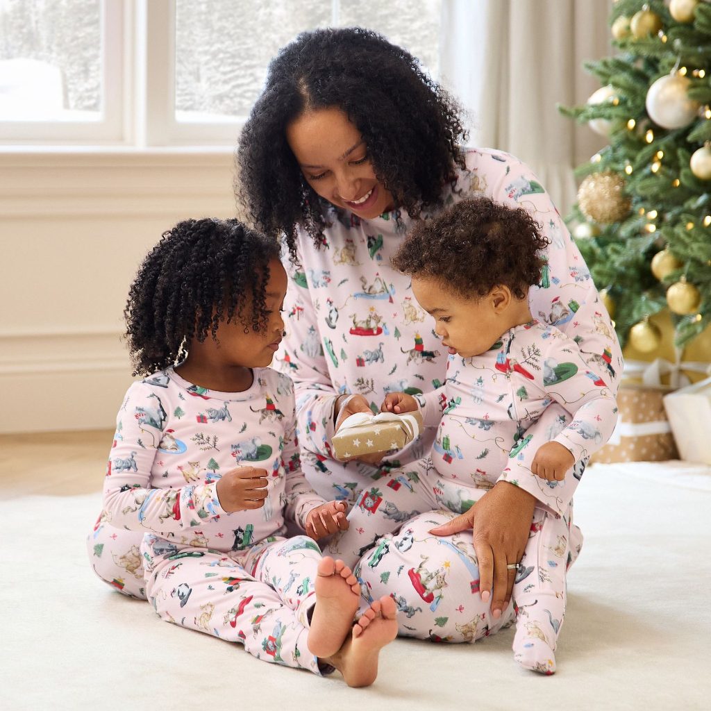 Mom and children wearing matching pink holiday cat pajamas